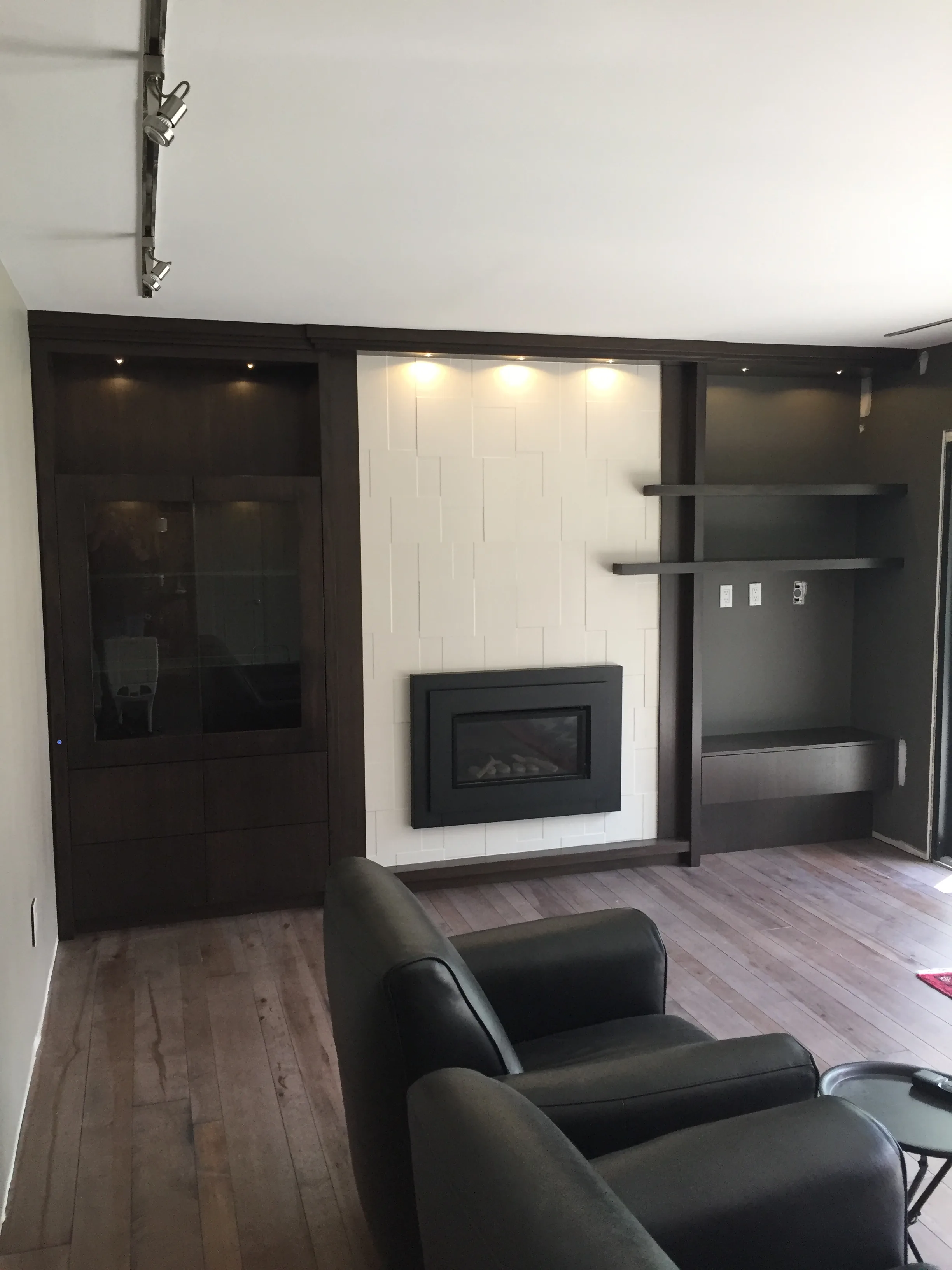 Dark wood built-in surround with white subway tile and stone insert