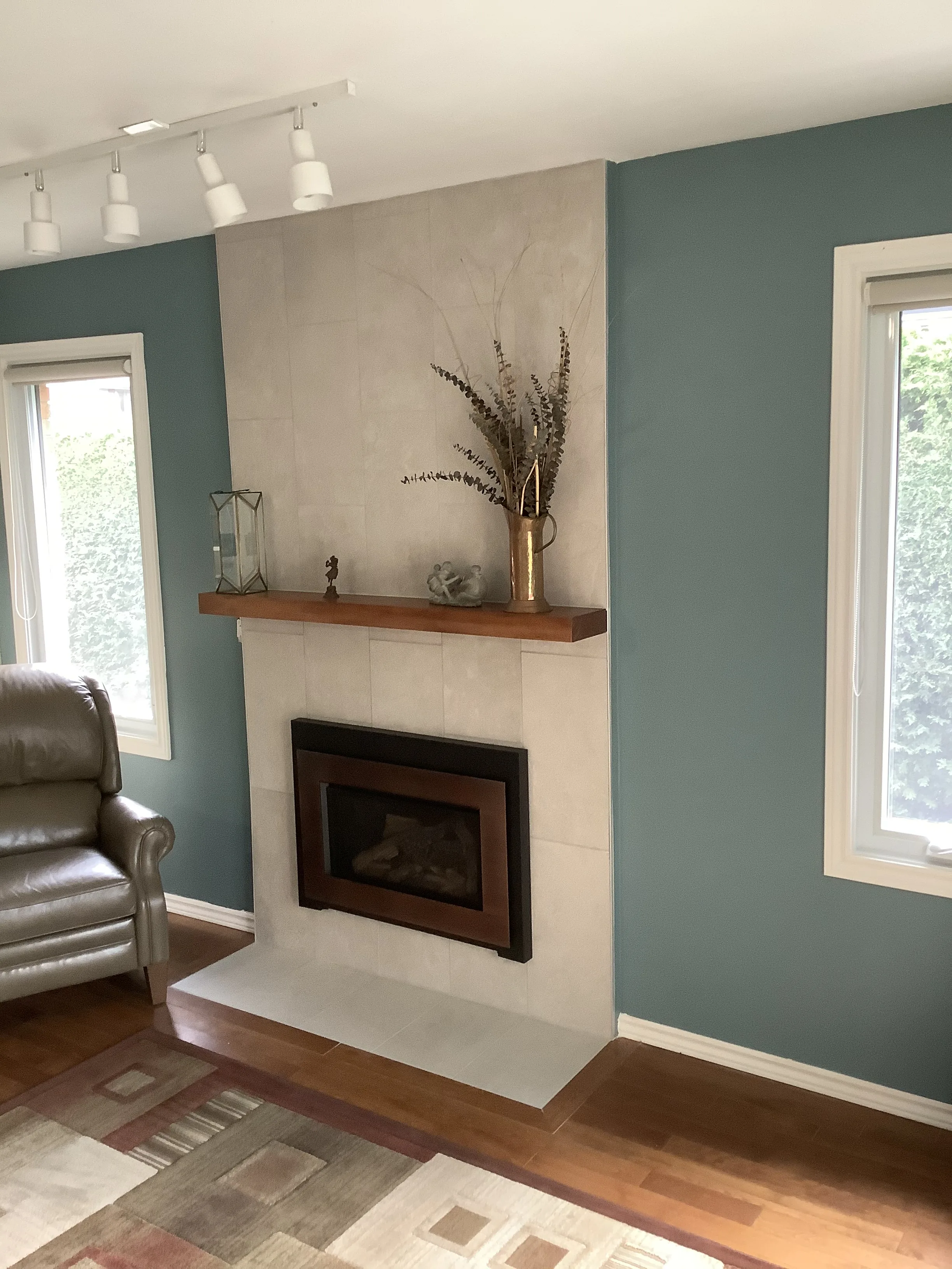 Cream tile fireplace with reclaimed wood mantel and framed art