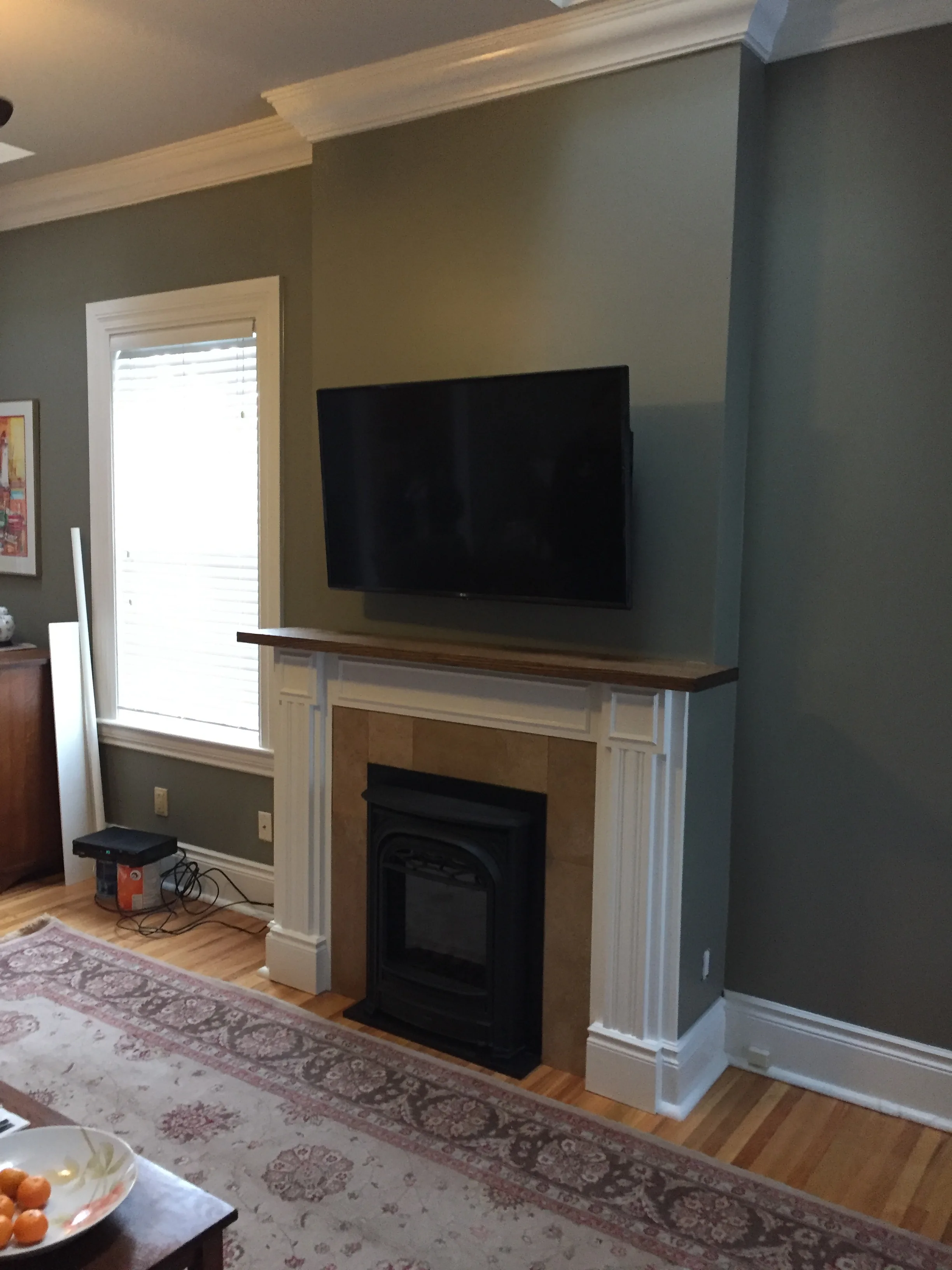 Traditional white bookshelf surround with stacked-stone fireplace and rustic wood mantel